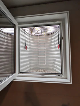 Egress window well grate locks installed on a basement window well, enhancing safety and emergency access.