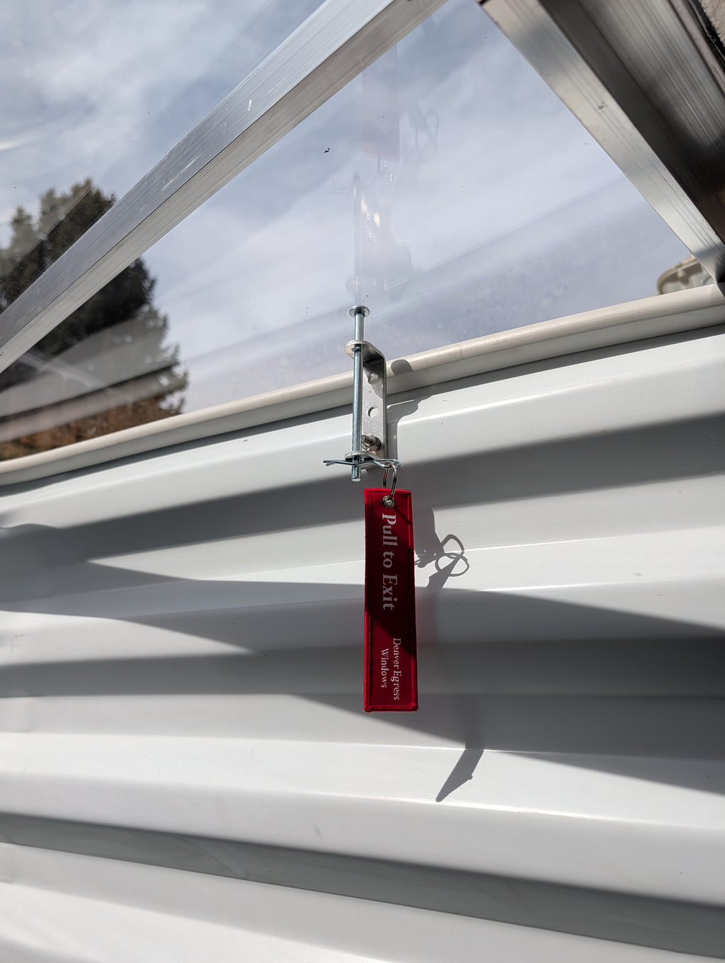 Egress window well cover locks installed on a polycarbonate window well to secure emergency escape.