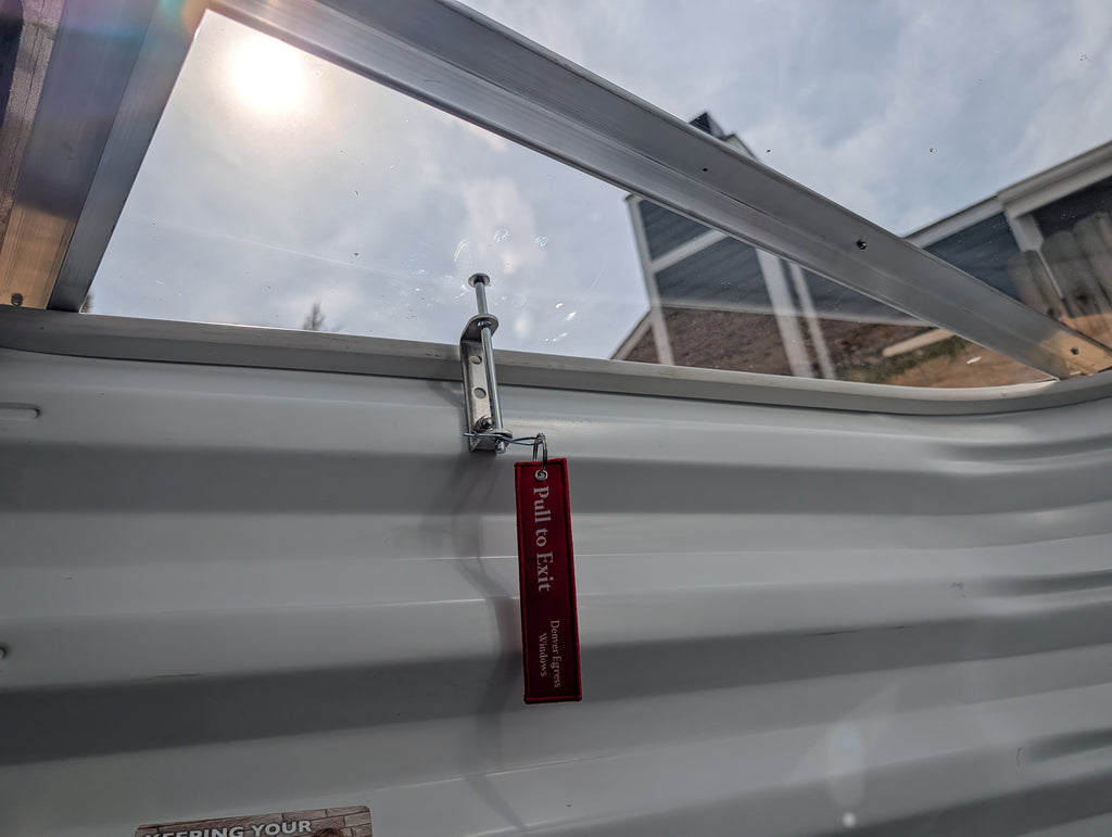 Egress window well cover locks securely fasten window well covers, featuring a safety pull to exit mechanism.