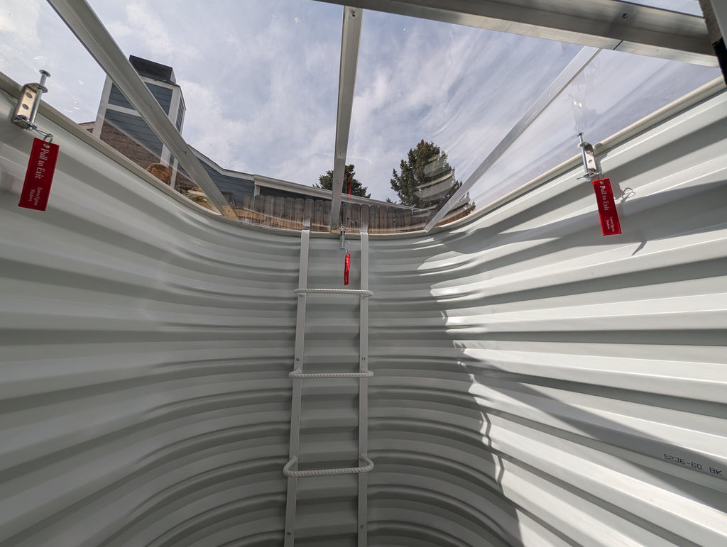 Inside view of egress window well cover showing locks and ladder for secure emergency escape.