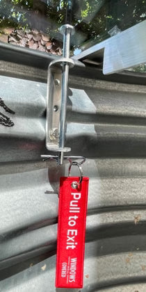 Egress window well cover locks installed on a polycarbonate window well to secure emergency escape.